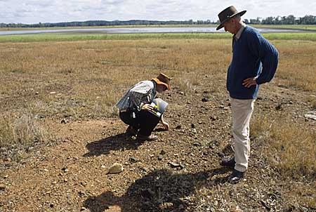 Thom Blake (squatting) and Jim Archer looking at an old campfire site