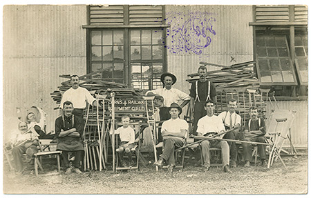 Ten men and one boy with chairs and crutches